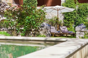 Alberca al aire libre y camastros 