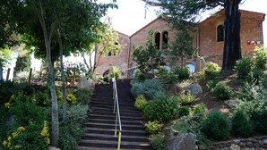 A set of stone steps leading up to a brick building with arched windows and a small door. - Can Ribalta Hotel Gastronòmic (Sant Antoni de Vilamajor)