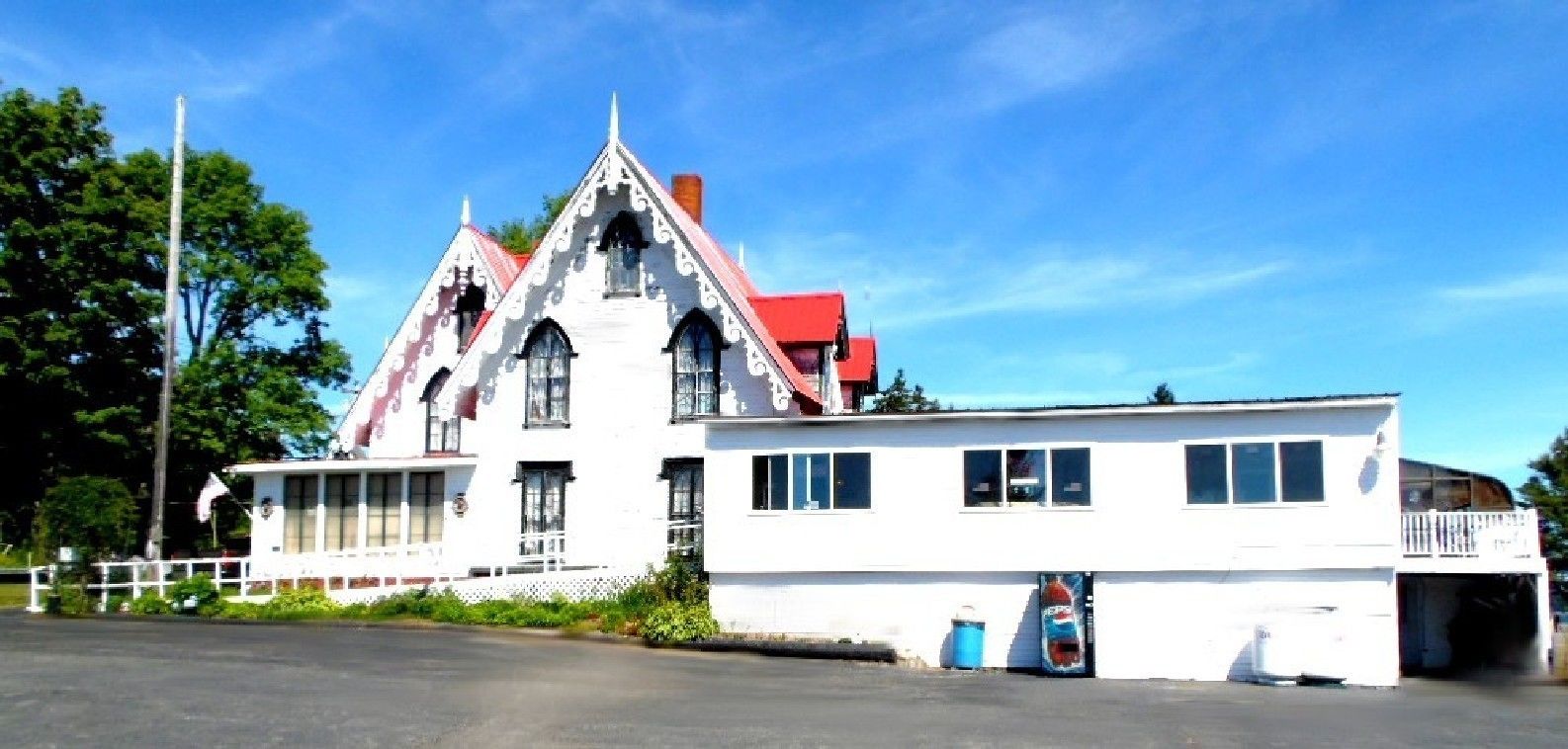 Un edificio grande de color blanco con techo rojo, varias ventanas y un balcón.