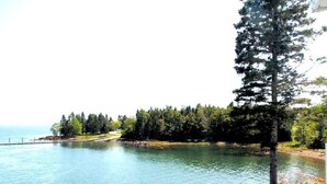 Un lac avec une terrasse en bois au premier plan.