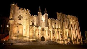 A large, illuminated castle with multiple towers and arched windows.