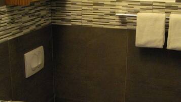 Ein Badezimmer mit Waschbecken, Toilette und Handtuchhalter mit gefalteten Handtüchern.