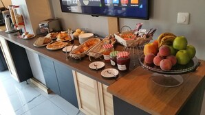 En morgenmadsbuffet med forskellige retter og et udvalg af frugt.