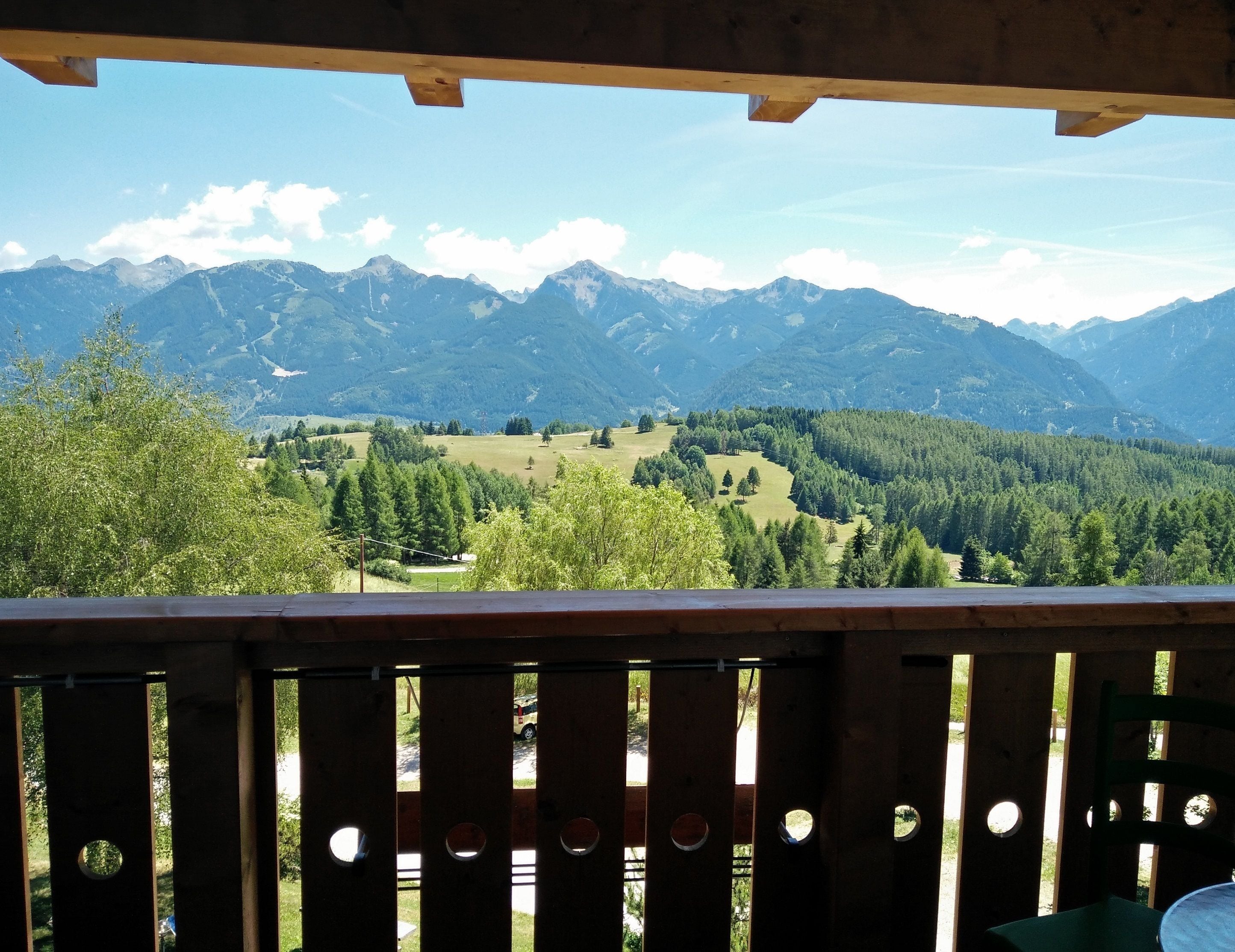 Eine Holzterrasse mit Blick auf eine gebirgige Landschaft.