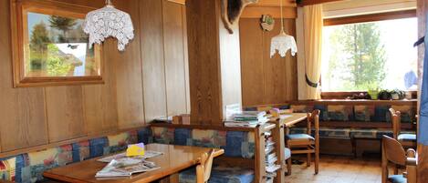Interior de madera con comedor, bancos y un trofeo de caza.
