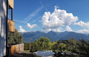 Eine Holzterrasse mit Blick auf Berge und einen klaren Himmel.