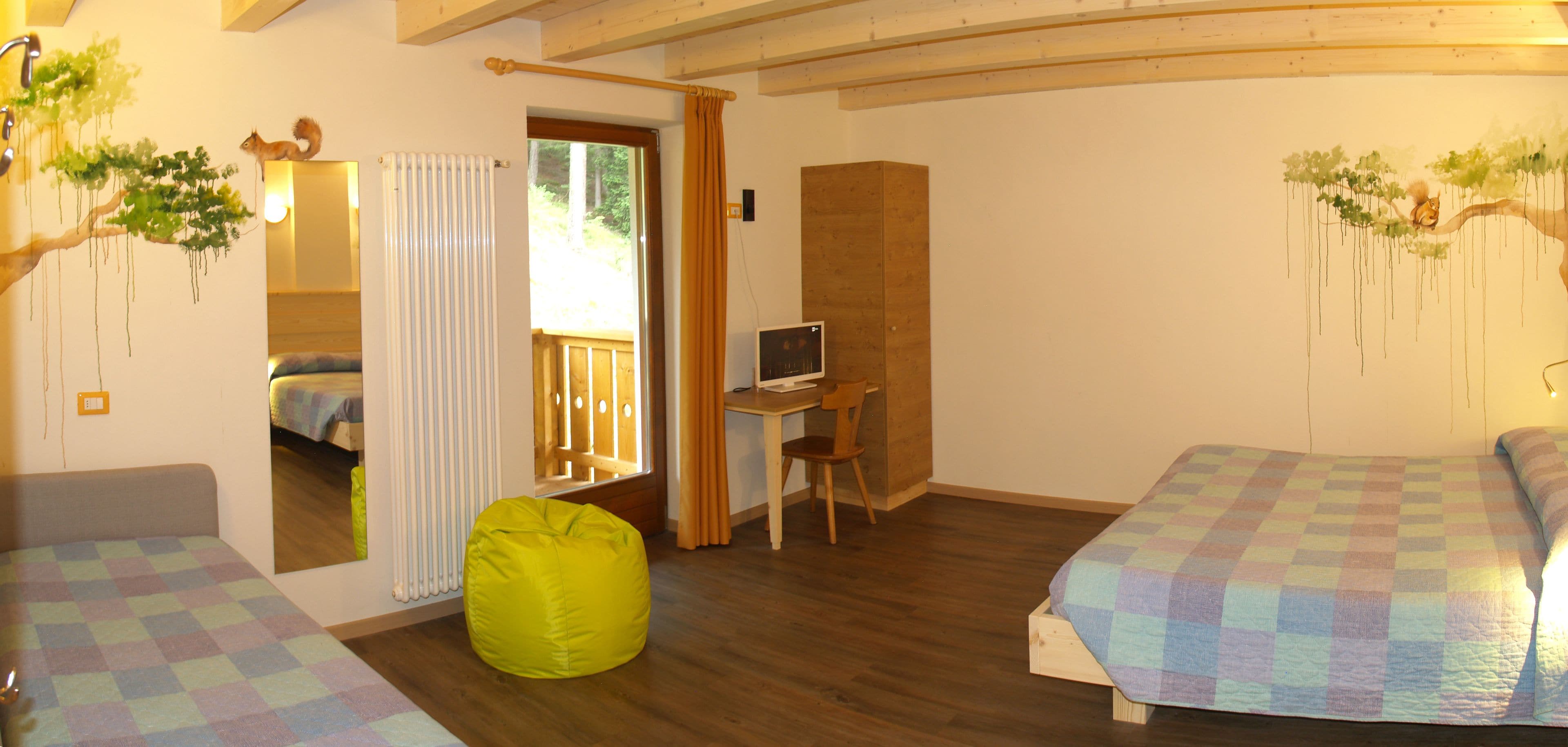 A bedroom with a bed, a desk, and a bean bag chair.
