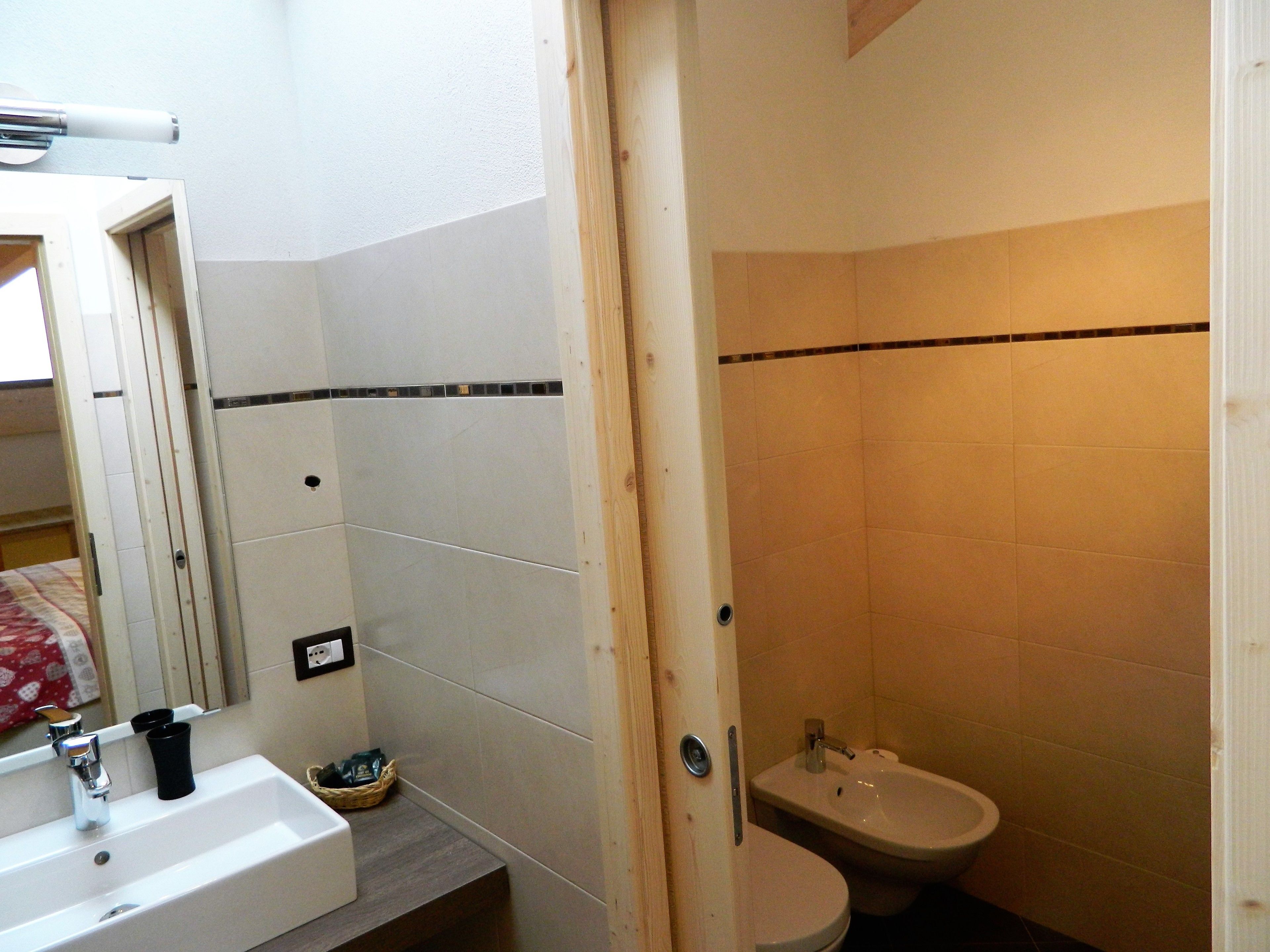 Une salle de bain équipée d’un lavabo, d’un bidet et d’un miroir.