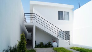 A modern white building with a staircase leading to an upper level.