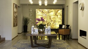 A reception area with a wooden table, potted plants, and a decorative wall. - Hotel Love It CAS Consulate (Guadalajara)