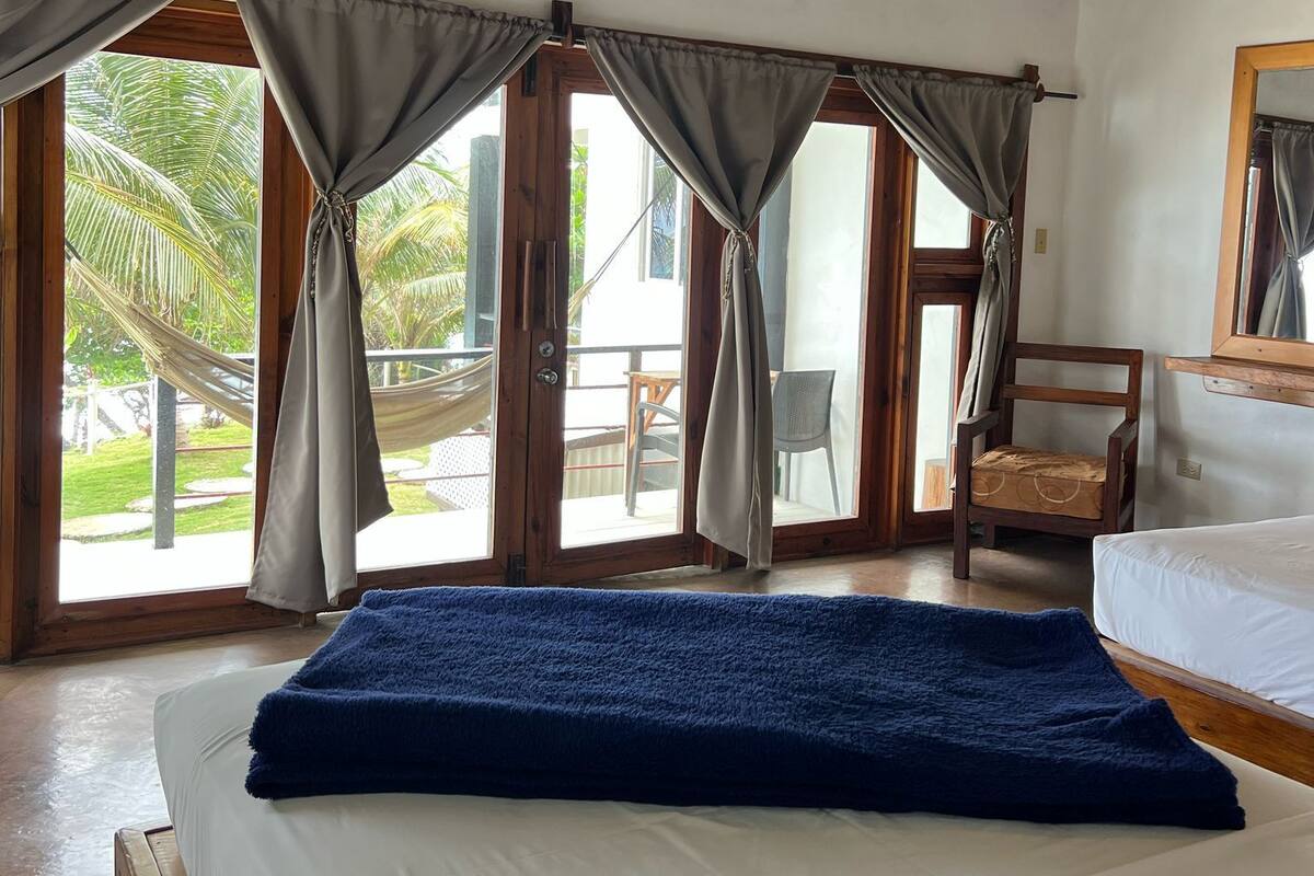 Un dormitorio con una cama, una silla y vistas al exterior.