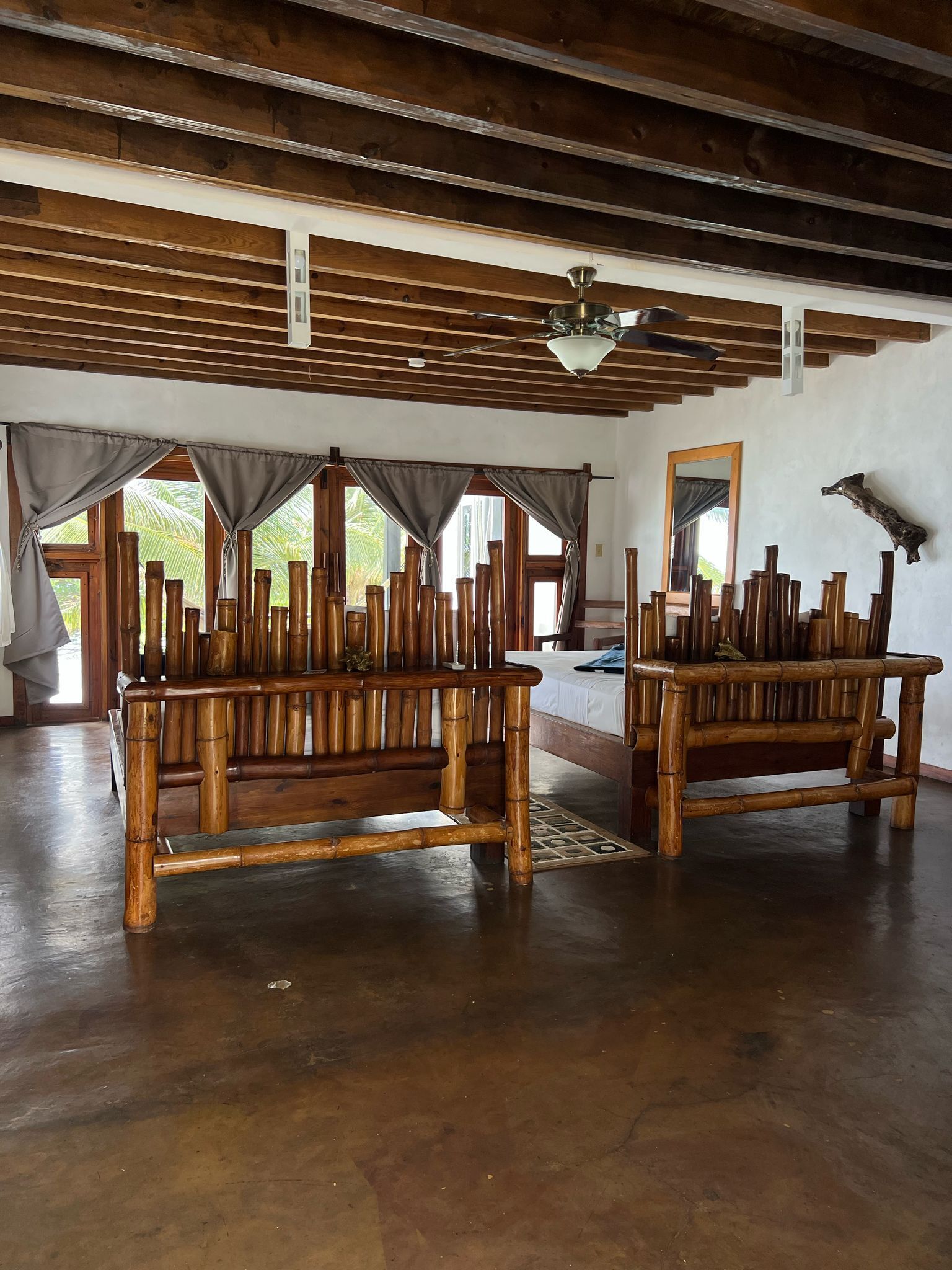 Amplia habitación con techo alto y vigas de madera, que incluye dos bancos de madera y una cama.