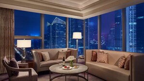 A modern hotel room with a city view, a round coffee table, a sofa, and a chair. - Palm Springs Hotel Chengdu, Vignette Collection by IHG (Chengdu)