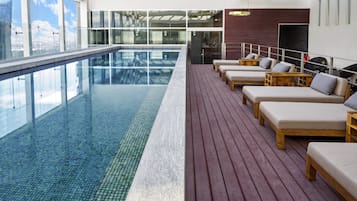 Una piscina techada, sillones reclinables de piscina