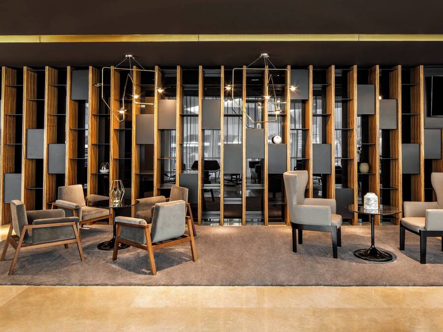 A modern lounge area with sofas, a coffee table, and a TV mounted on the wall.