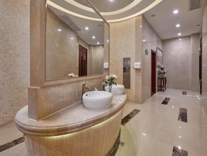 A modern bathroom with a curved vanity, a large mirror, and a wall-mounted sink. - Vienna Classic Hotel(Dongguan Chang'an West Railway Station Modern City Store) (Dongguan)
