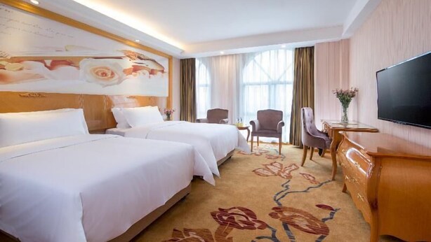 A hotel room with two beds, a TV, a desk, and a large window with curtains. - Viennaclassic Hotel Shenzhen Bantian Wuhe Avenue (Shenzhen)