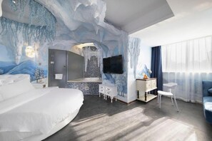A modern hotel room with a large bed, a seating area, a television, and a bathroom with a mosaic tile wall. - Viennahotel Shenzhen Exibition Center (Shenzhen)