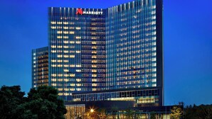 Een modern hoog hotel met een Marriott logo, met een raster van ramen en een plat dak.