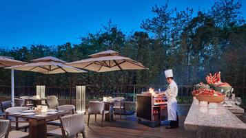 An outdoor dining area with tables, chairs, and umbrellas.