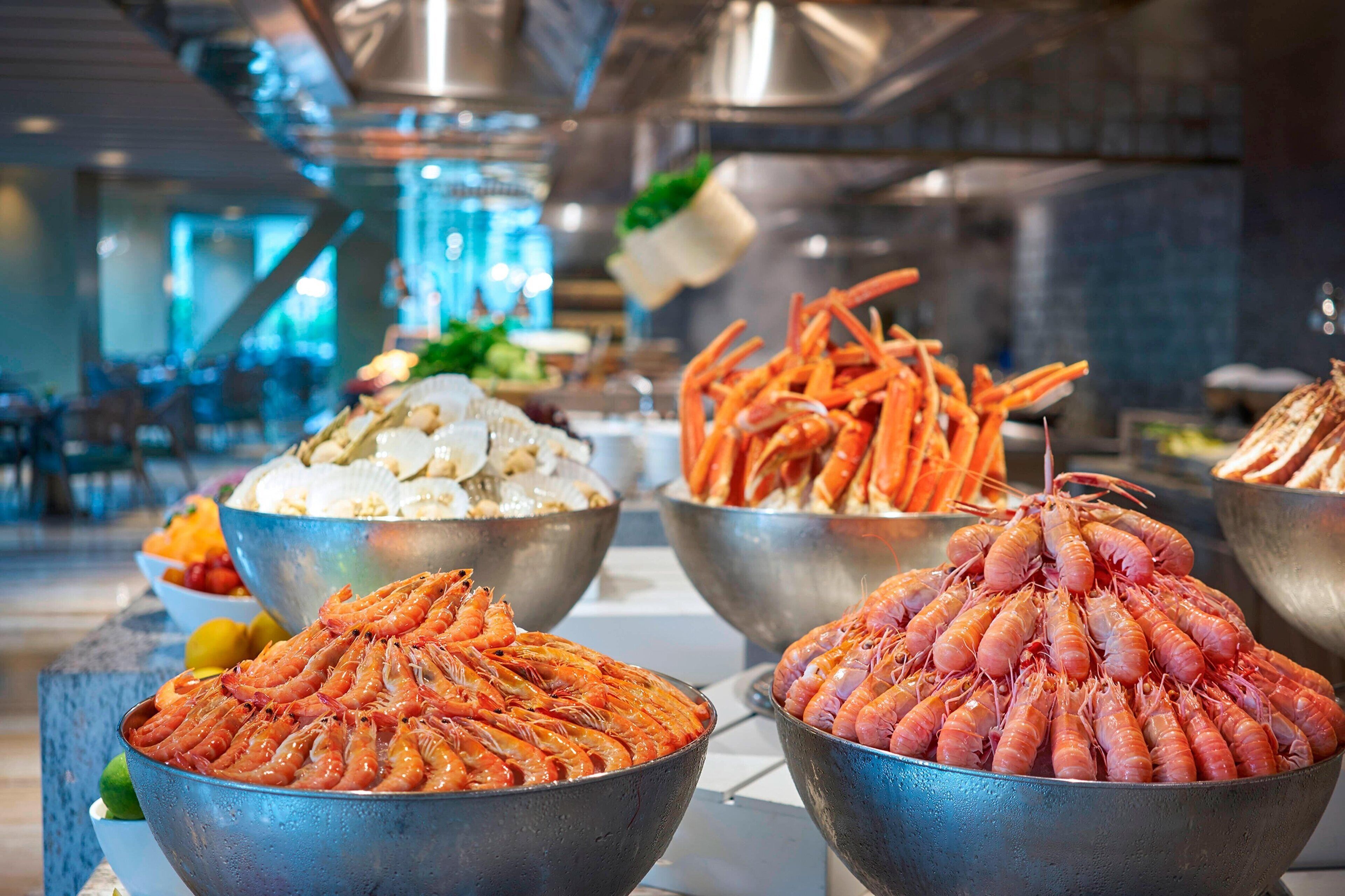 Un buffet proposant une variété de fruits de mer, notamment des crevettes, des queues de crabe et du homard.