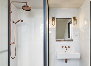A bathroom with a shower, a sink, and a mirror. - The Hoxton, Paris (Paris)