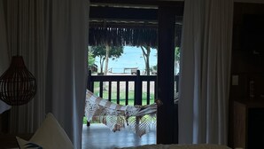 Una camera da letto con un letto, una lampada a sospensione e vista su un patio e alberi.