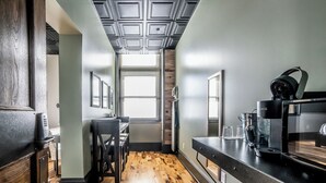 Een moderne keuken met houten vloeren, een ingebouwde magnetron en een koffiezetapparaat.