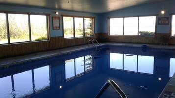 Una piscina techada, sillones reclinables de piscina