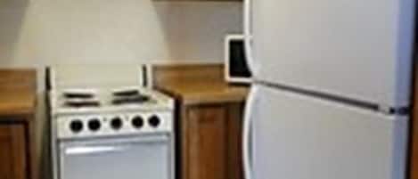 Eine Küche mit Holzausstattung, einem weißen Herd und einem weißen Kühlschrank.