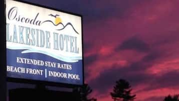 Señal del Hotel Lakeside que anuncia tarifas para estancias prolongadas, vista frente a la playa y piscina cubierta.