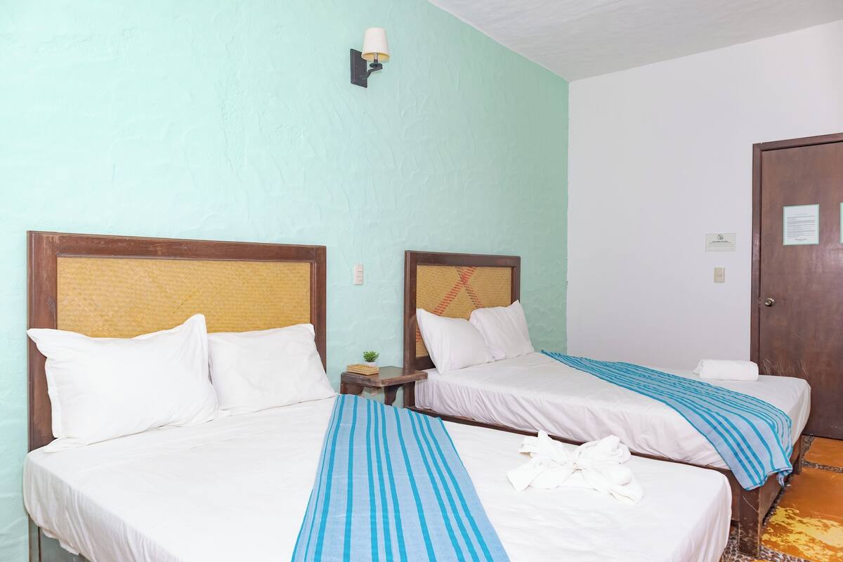 Two single beds with wooden headboards, white bedding, and blue striped bedspreads.