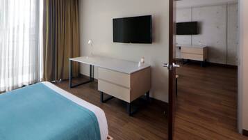 Una habitación de hotel con una cama, un escritorio, un televisor y un armario.