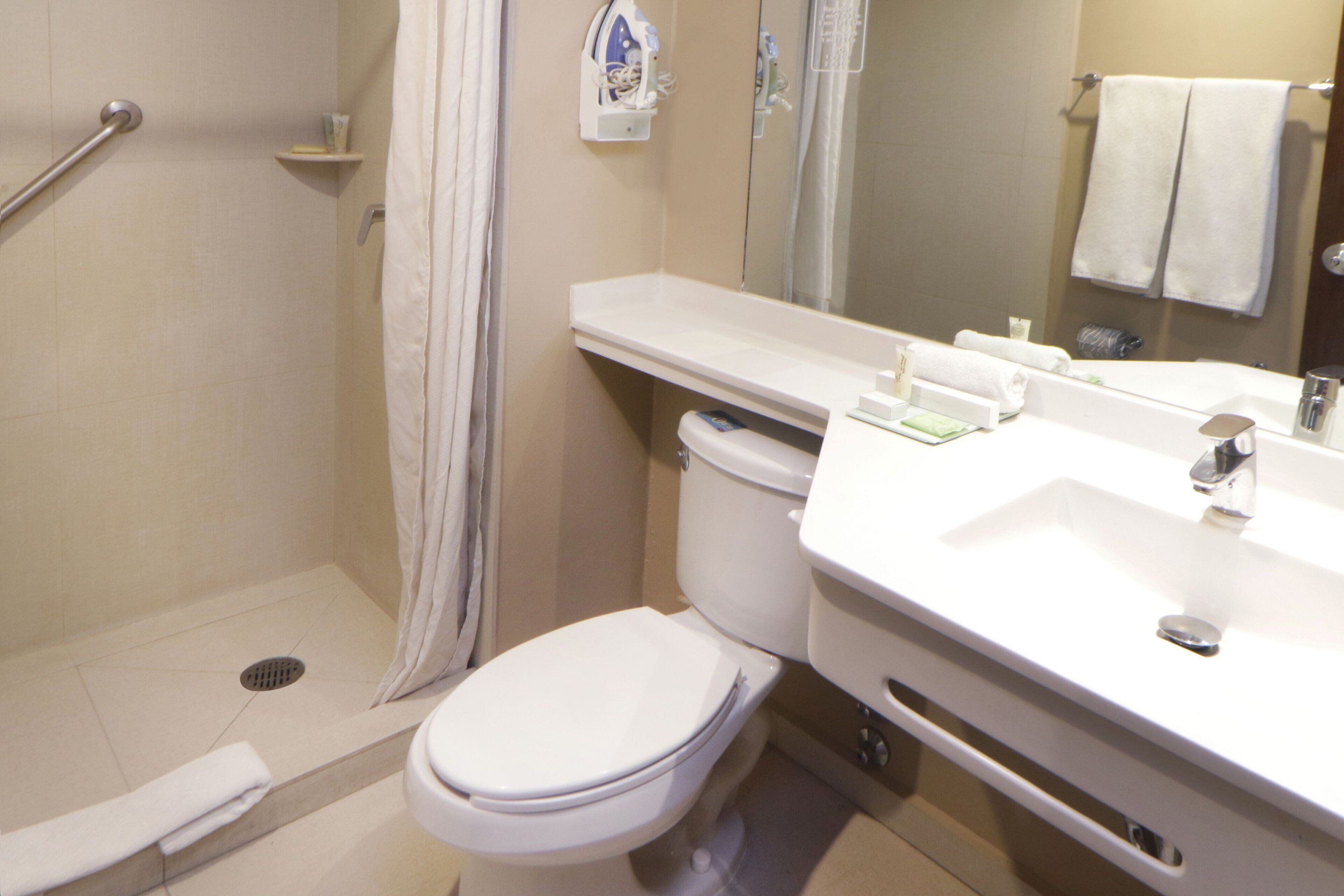 A bathroom with a shower, toilet, and sink.