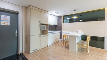 Una cocina moderna con microondas, fregadero y sillas de madera.