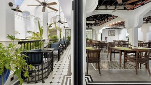 Un comedor interior con techos altos, ventanas arqueadas y ventiladores de techo.