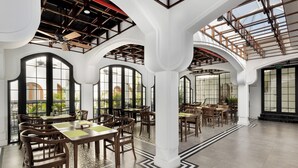 Un comedor espacioso con techos altos, ventanas amplias y mobiliario de madera.