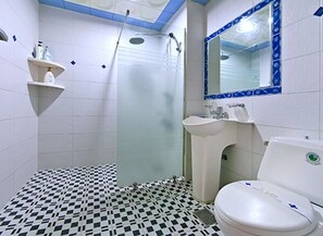 A bathroom with a checkered floor, a sink, a toilet, and a shower. - Drama Motel (Boryeong)