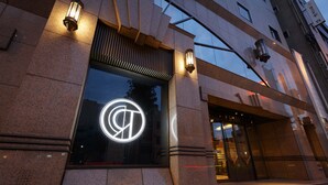 A building entrance with a large glass window displaying a logo. - Royal Park Hotel Takamatsu (Takamatsu)