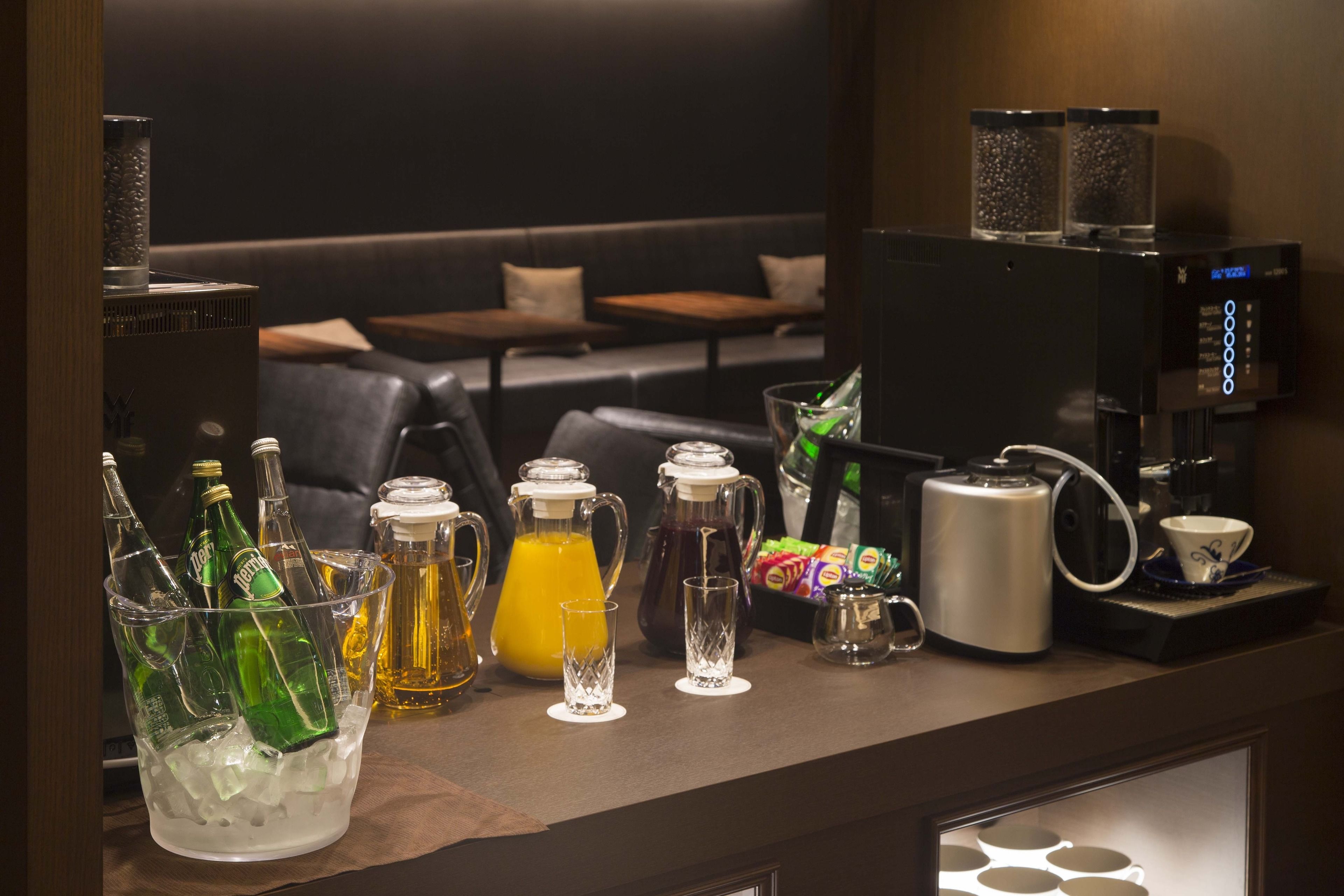 A bar area with bottles, a pitcher, and a coffee machine.