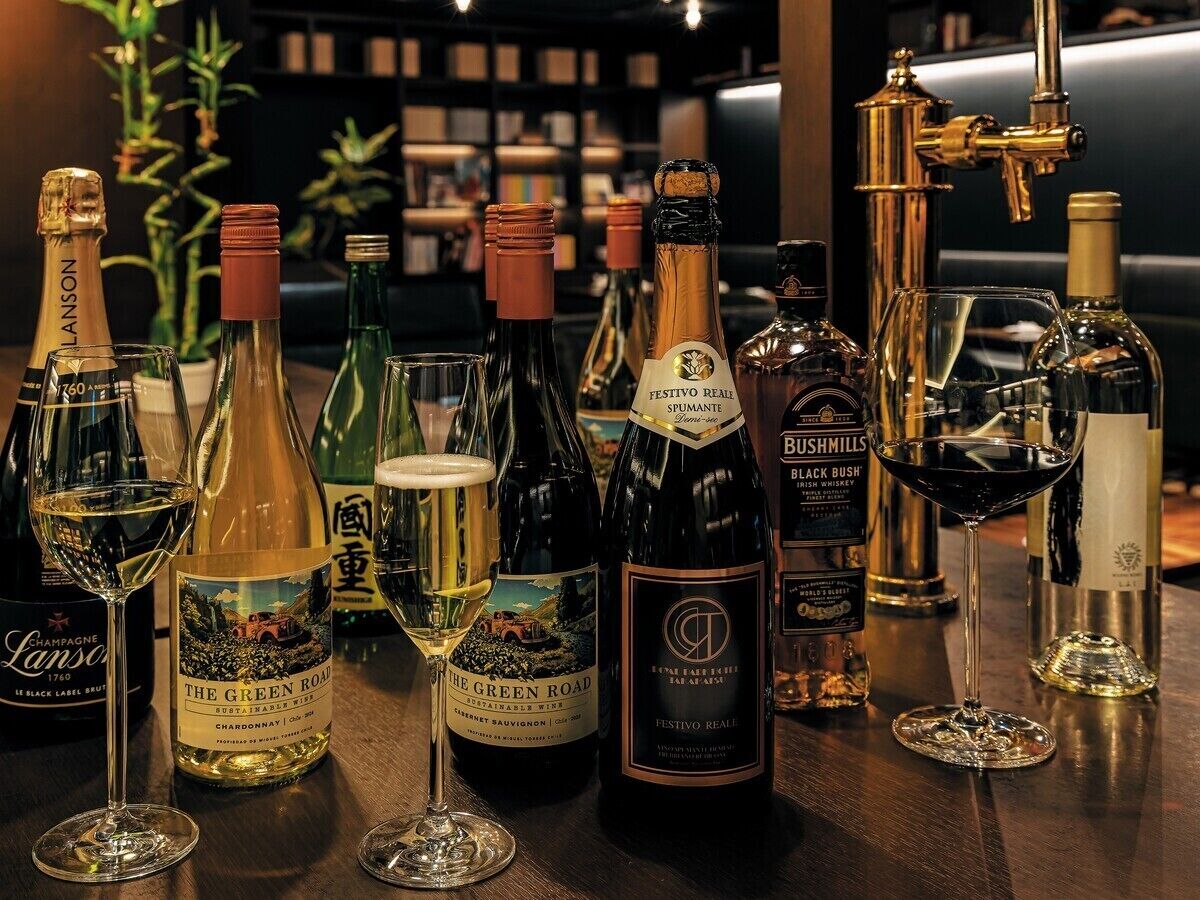 Variedad de botellas y copas de vino sobre una barra.