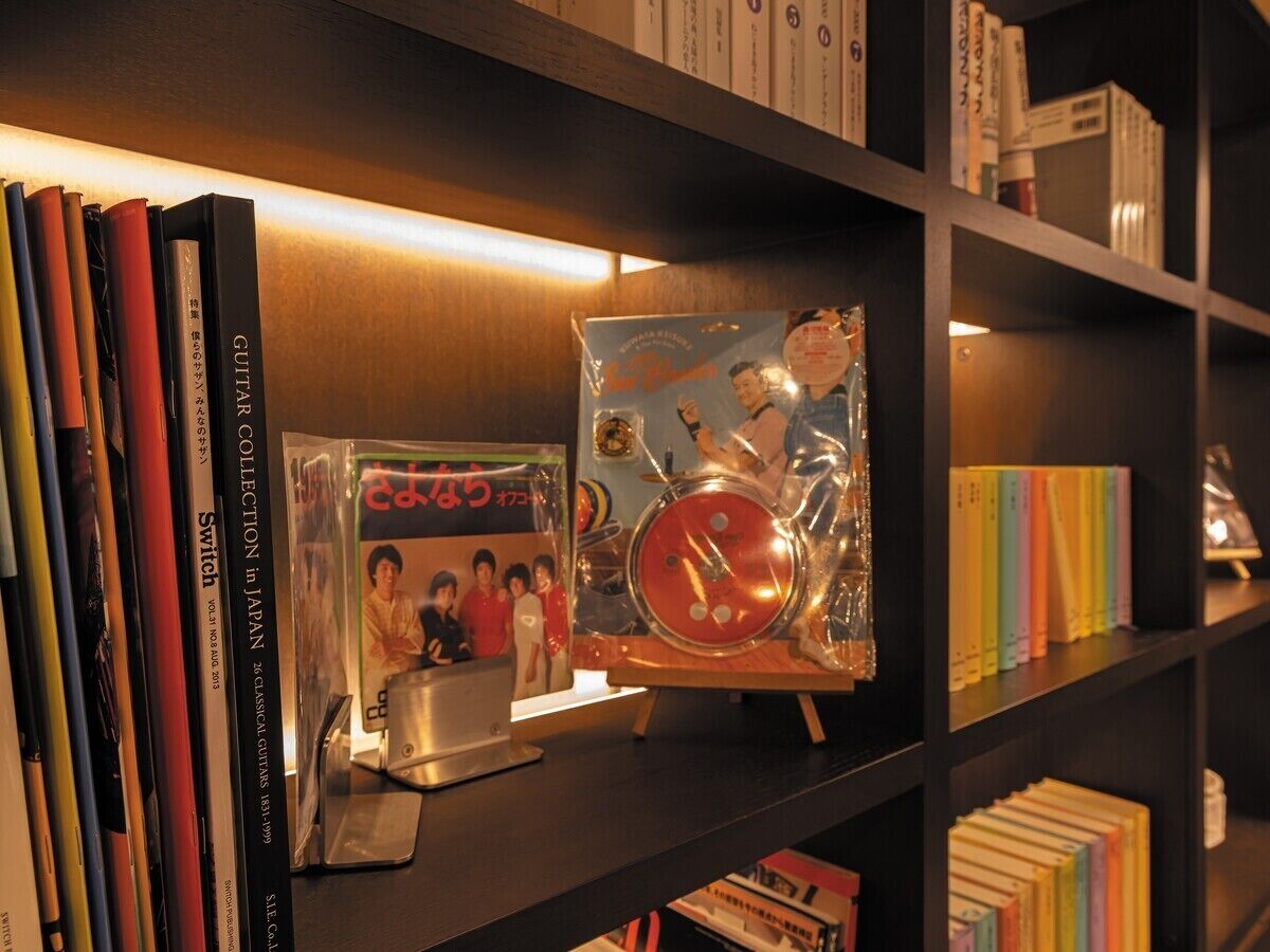 A bookshelf with books and a drum set.