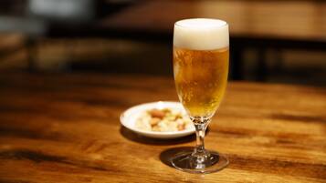 Een glas bier op een houten tafel, met een wazige achtergrond.