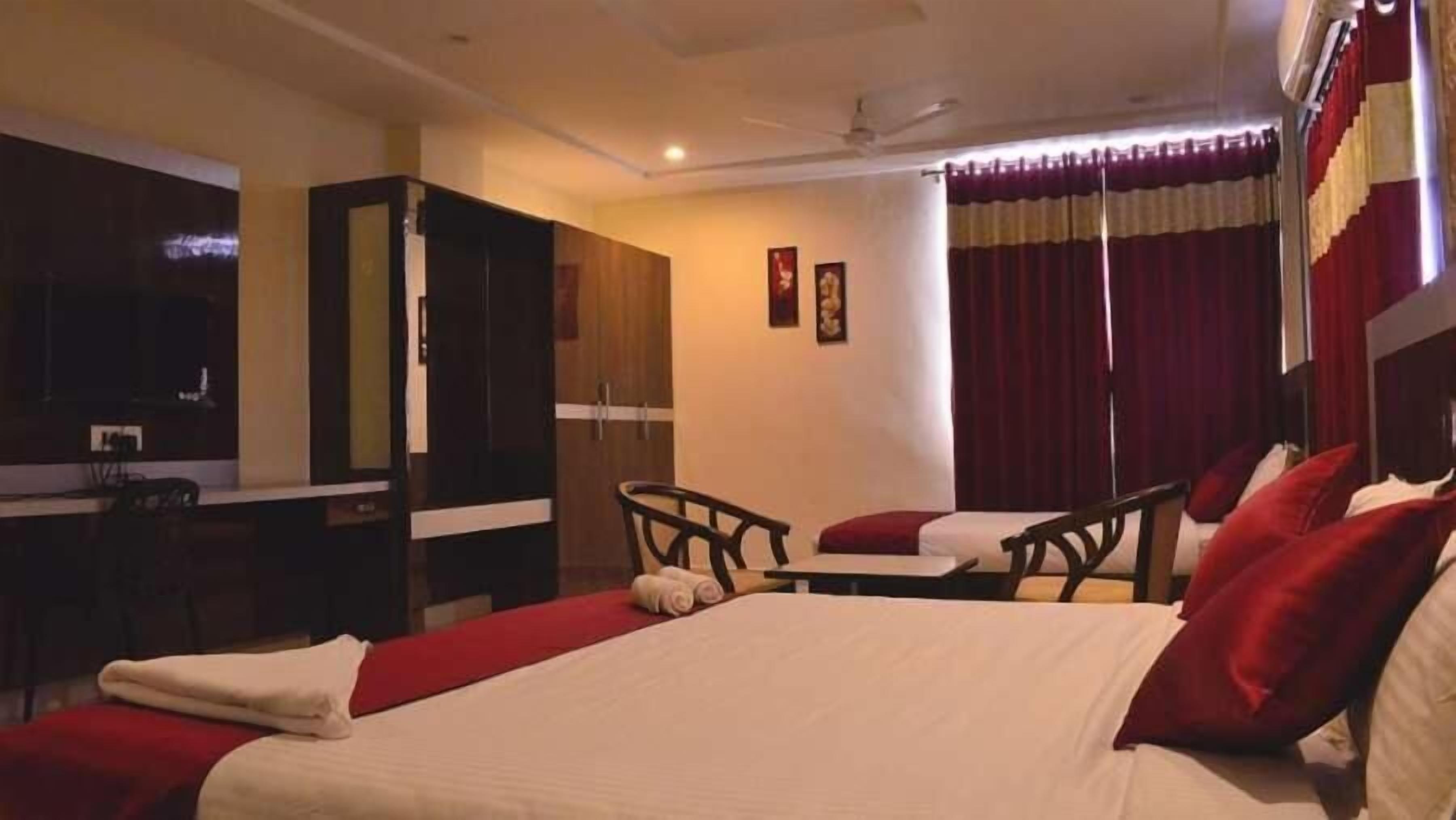 A hotel room with a large bed, a desk, and a wardrobe.