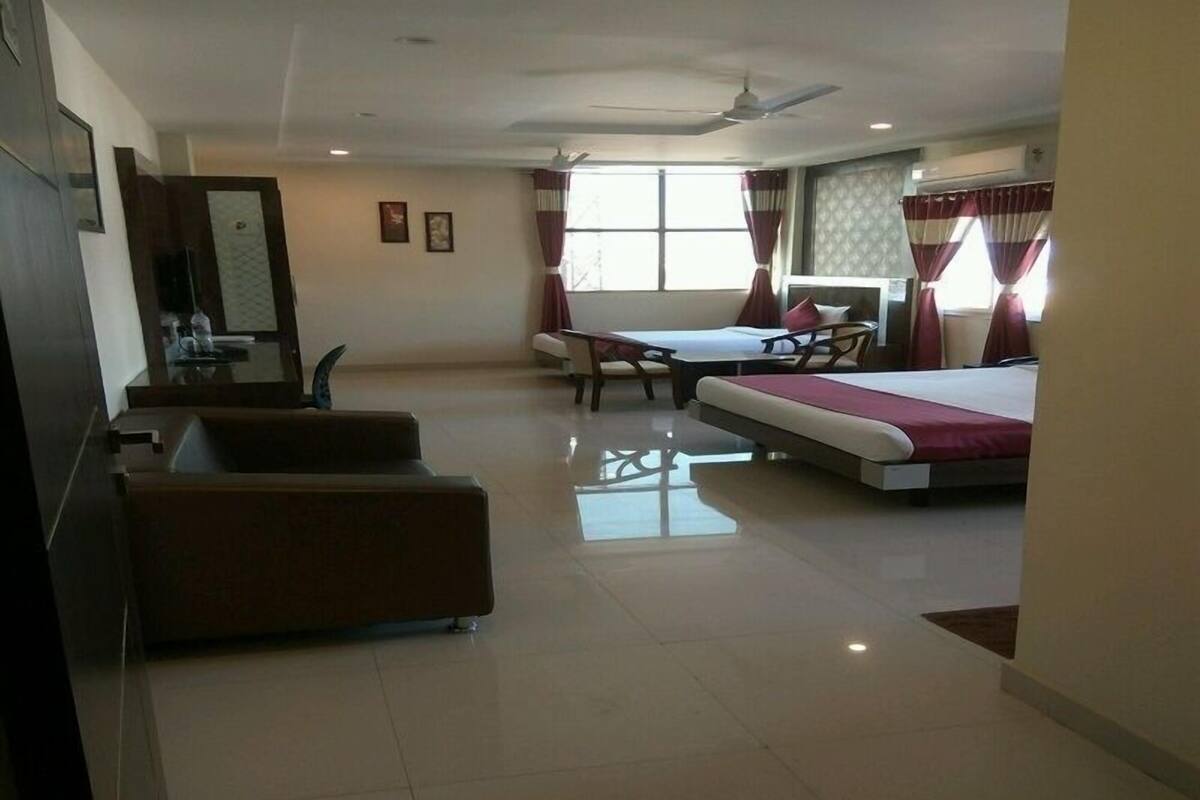 A hotel room with a bed, a sofa, a desk, and a chair.