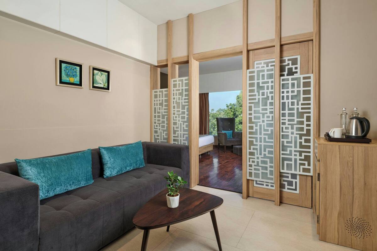 Una sala de estar moderna con un sofá, una mesa de centro y vistas a través de un separador de madera.