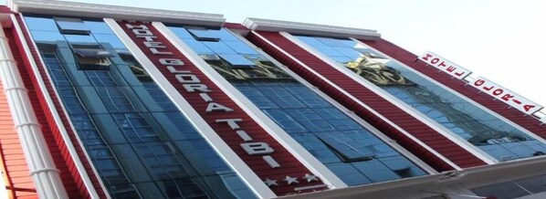 Un edificio de hotel con fachada moderna, amplios ventanales de vidrio y un cartel llamativo que dice "HOTEL BORIATIBI".
