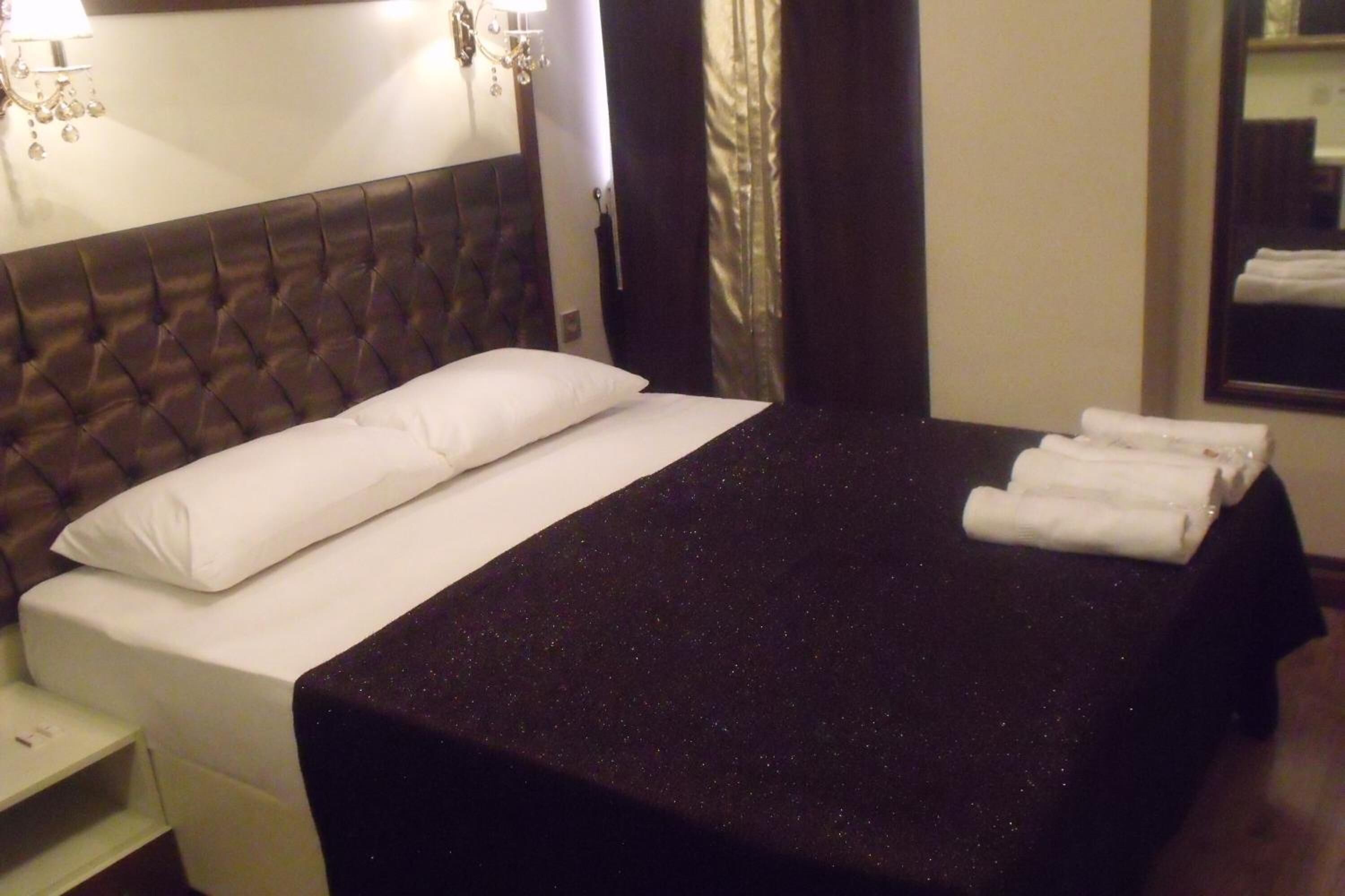 Ein Hotelzimmer mit einem großen Bett, einem Nachttisch und einem Spiegel.