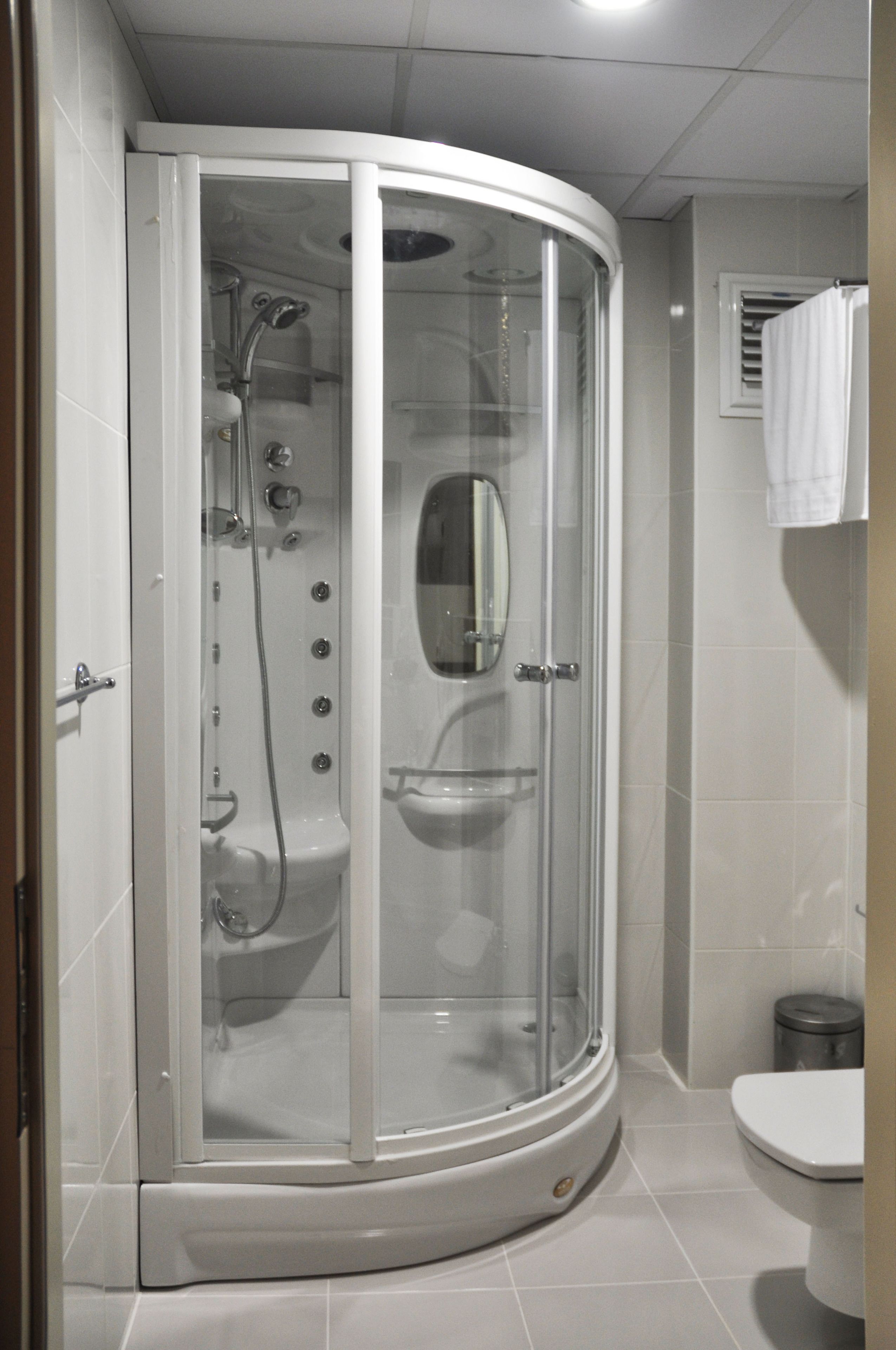 Une salle de bain moderne avec une douche à parois de verre, des toilettes et un lavabo.