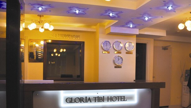 Una recepción con un cartel que dice "GLORIA TIBI HOTEL".